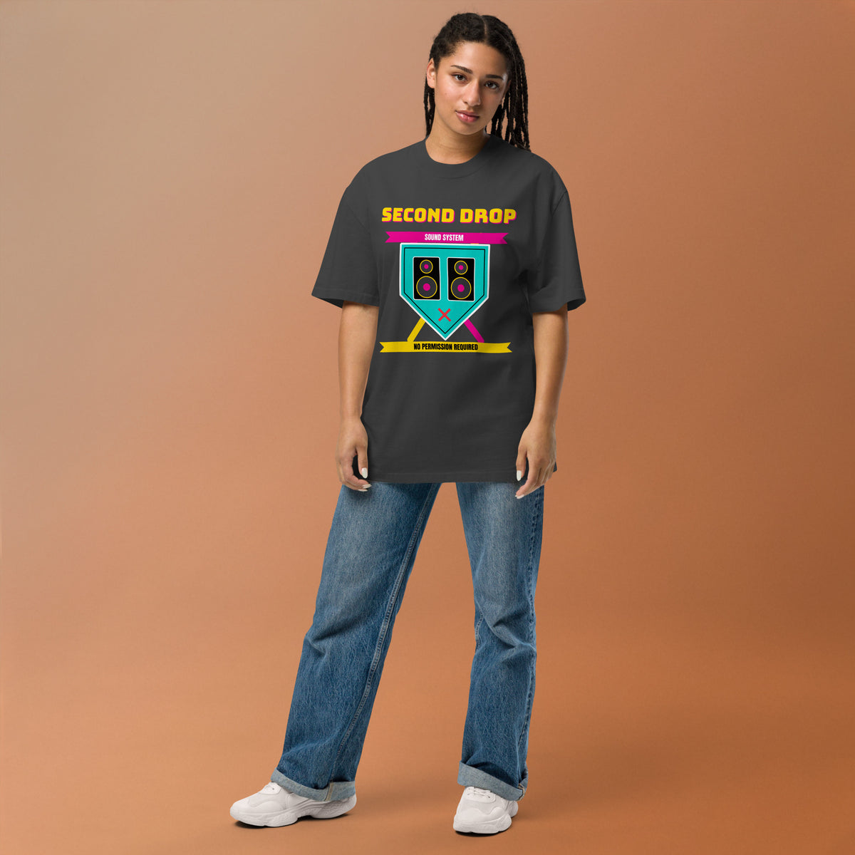 Person wearing a black t-shirt with a graphic design The Second Drop on a brown background