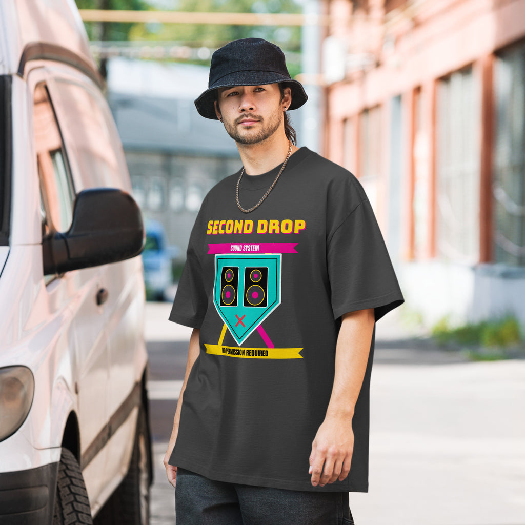 Man wearing a black t-shirt with a graphic design standing next to a vehicle.